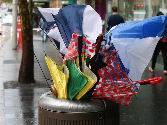 broken umbrellas in trash can