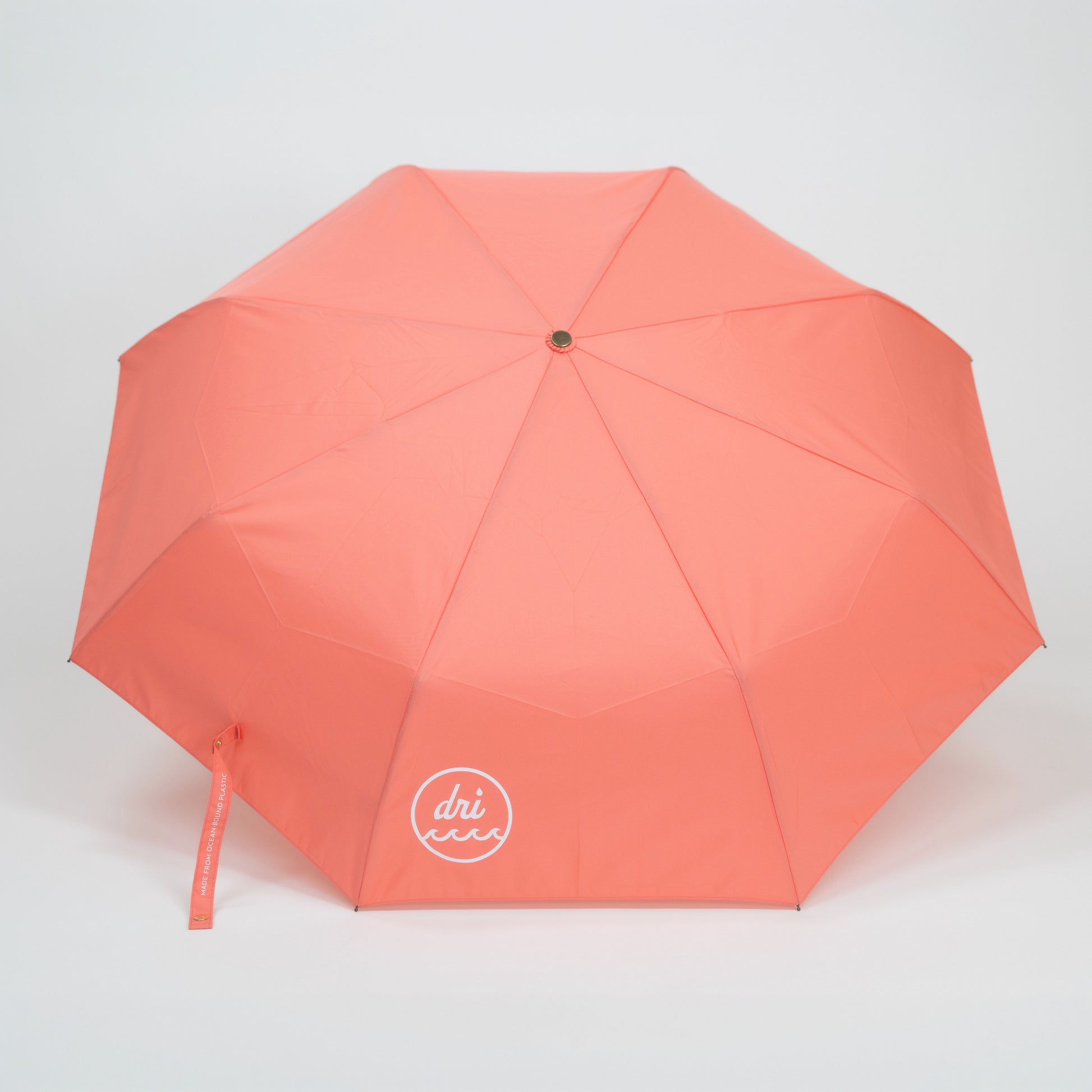 Coral umbrella with a brand logo on a light gray background